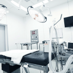 A clean, brightly lit, slightly out-of-focus background showing a portion of a medical consultation room