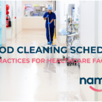 Healthcare cleaner mopping a hospital corridor with medical equipment nearby, illustrating the importance of routine and scheduled cleaning in clinical environments.