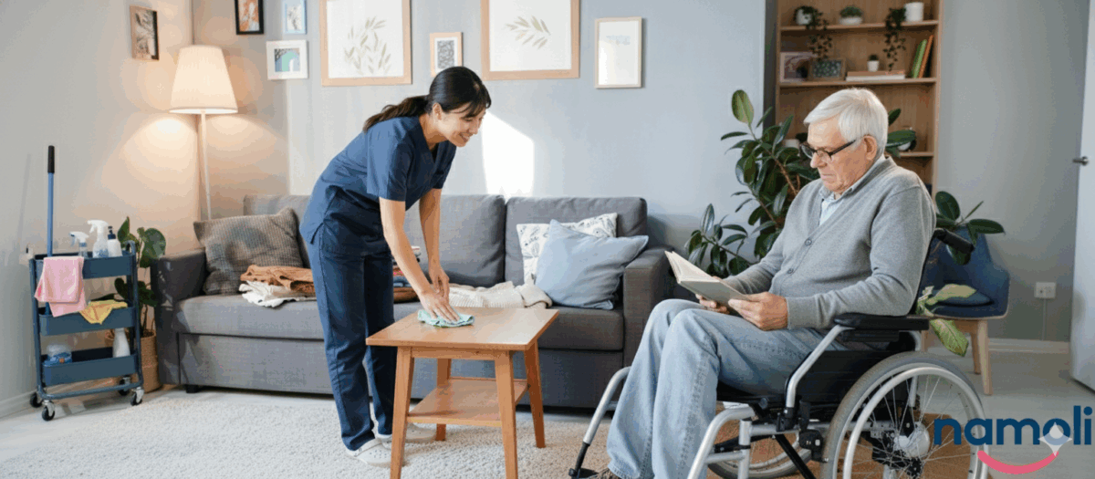 A dedicated caregiver in a navy uniform cleaning a surface in a comfortable, modern aged care setting, focusing on maintaining a tidy environment for a senior resident.