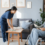 A dedicated caregiver in a navy uniform cleaning a surface in a comfortable, modern aged care setting, focusing on maintaining a tidy environment for a senior resident.